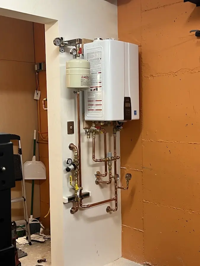 Plumbing technician inspecting water heater connections in Randleman